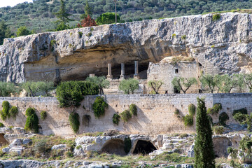 Buildings and columns under the cliff near church Chiesa Rupestre Madonna della Stella and Ponte...