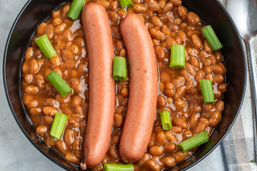 hot dogs  on baked beans top with green onions