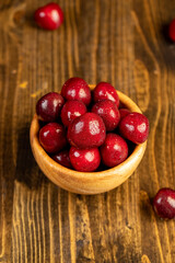 ripe cherry berries in drops of water, wet red cherry fruits on the kitchen table, The berries are scattered on the table