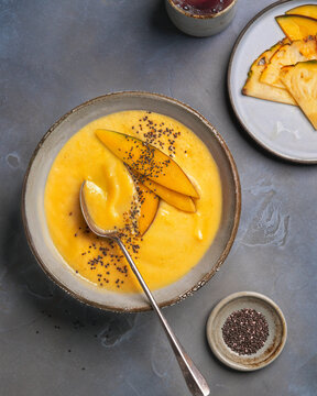 Minimalist tropical mango smoothie bowl with chia seeds and elegant food styling