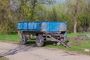 blue tractor trolley in the village in autumn bright