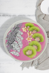 Pitaya smoothie bowl with fruit, kiwi, banana, and poppy seeds. Trendy food, healthy breakfast idea