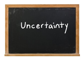 Obraz premium Uncertainty written in white chalk on a black chalkboard