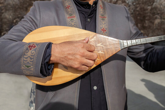 man plays the Kazakh folk instrument dombra. close-up of dombra in hands