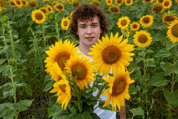 Man in white t-shirt holding bouquet of sunflowers