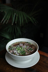Traditional Vietnamese pho soup with beef slices served in a white ceramic bowl. Concept of authentic Asian cuisine, healthy food, and comforting homemade meals.
