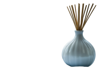 Elegant white ceramic diffuser vase with natural reed sticks against a stark black background creating a on transparent background