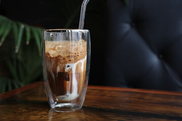 Traditional Vietnamese egg coffee with condensed milk and creamy foam on wooden table in a glass, copy space. Concept of enjoying unique Asian beverage, sweet flavor, and cultural coffee experience.