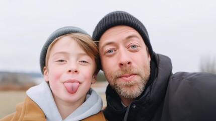 Two smiling individuals enjoy a cheerful moment outdoors during a cool day, capturing joyful expressions and playful gestures.