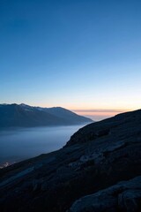 Obraz premium mountains with a low cloud line and a person standing on a mountain