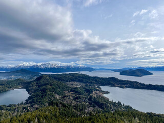 Beautiful range of snowy mountains and a lake with blue sky above in Bariloche Argentina, amazing panoramic view at Circuito Chico Patagonia.