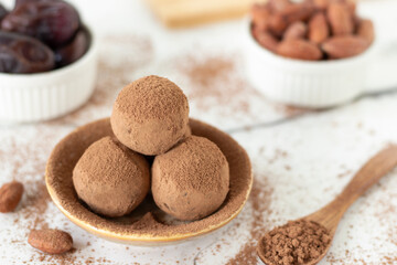 Chocolate truffles with cocoa powder and dates. Close-up. Healthy homemade raw dessert or snack.
