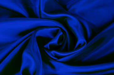 Top view of dark blue silk cloth with silky sheen suitable for design and wallpaper background.