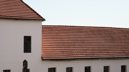 Tile roof details of an ancient castle with medieval stone architecture