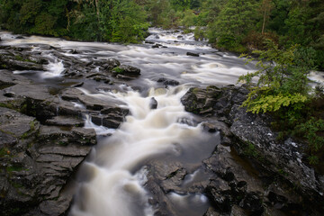 Rushing, white water rapids of the Falls of Dochart in the town of Killin, Perthshire, central Scotish highlands.