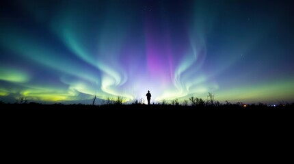 Fototapeta premium Person Watching the Aurora Borealis at Night Silhouette