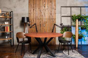 Engaging podcast setup featuring a wooden round table with microphones ready for an interview in a modern studio environment