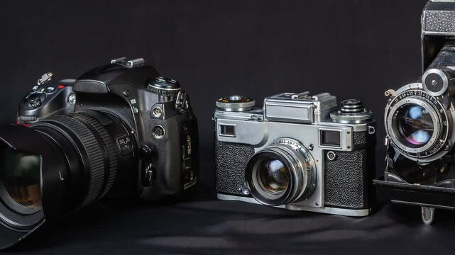 Different styles of cameras from vintage to modern sit side by side on a dark surface, highlighting advancements in photography technology over time.