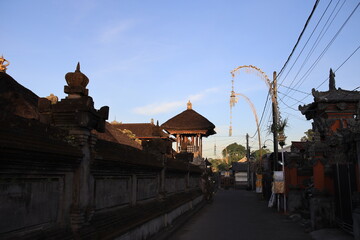 Street in a foreign country with a large building in the background. The street is empty and the sky is blue