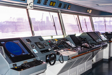 View of the control console on the navigational bridge of the cargo container ship. 