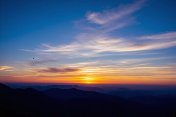 Obraz premium colorful sunset over a mountain range with a blue sky
