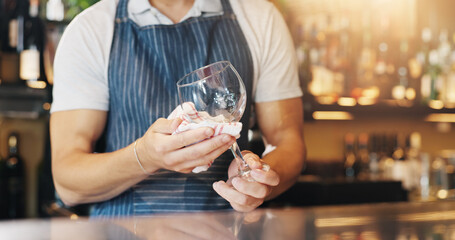 Waiter, hands and cleaning glass with cloth for hygiene, dust and service for drinks at restaurant. Person, bartender and check for shine with wipe, germs and inspection for dirt at small business