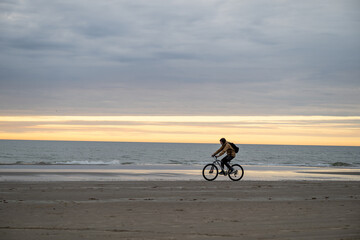 Fototapeta premium man riding bicycle on North sea coast in Denmark