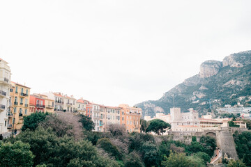 Fototapeta premium Colorful hillside buildings and historic castle with mountain backdrop in Mediterranean town