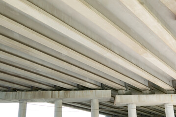 Obraz premium Abstract industrial photo with bottom view of a road bridge with concrete pillars.