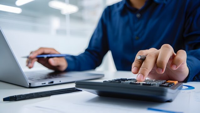 Close up businessman hand using calculator to budgeting and tax calculation monthly expenses. budget management and accounting on table. Business finance accounting banking concept.