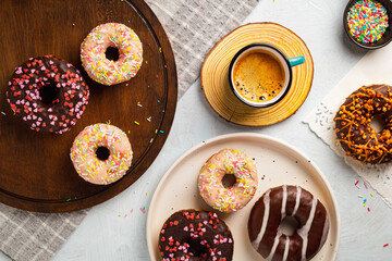 Various onuts and cup of coffee on a white background. Top view