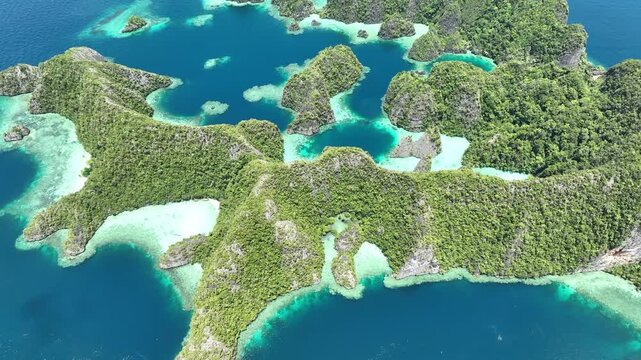 A set of scenic limestone islands rise from the ocean in Misool, Raja Ampat, Indonesia. This area is known as the heart of marine biodiversity and is a popular destination for diving and snorkeling.