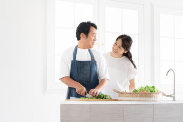 料理をする夫と見守る妻