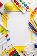 Creative vertical school and art supplies arranged neatly around a central blank paper sheet