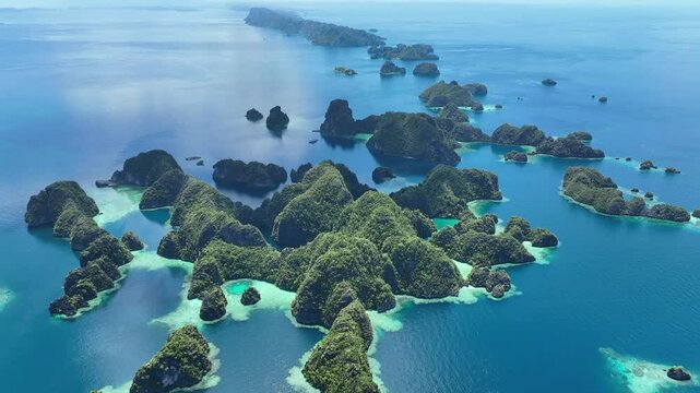 A set of scenic limestone islands rise from the ocean in Misool, Raja Ampat, Indonesia. This area is known as the heart of marine biodiversity and is a popular destination for diving and snorkeling.