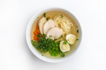 Chicken soup with noodles and vegetables in a bowl isolated on white background