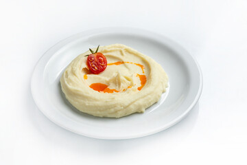mashed potatoes with tomato on a white plate on a white background