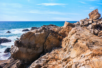 Coastal cliffs along California's Highway 1 in Northern California. Rugged ocean rocks, crashing waves, and a colorful sky create a breathtaking Pacific Coast landscape