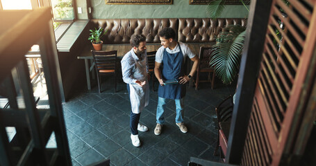 Men, waiter and meeting with tablet at cafe for discussion, planning and stock checklist. Above, people and talk with digital for inventory management, online orders and feedback of menu information