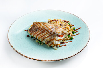 Grilled fish fillet with bulgur and vegetables on white background