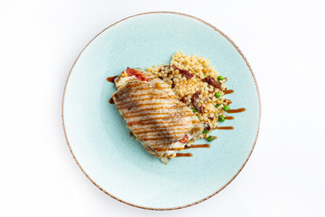 Grilled fish fillet with bulgur and vegetables on white background