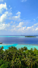 Scenic panoramic view of tropical islands surrounded by deep blue ocean with palm trees in the foreground, maldives summer travel, island getaway, nature beauty