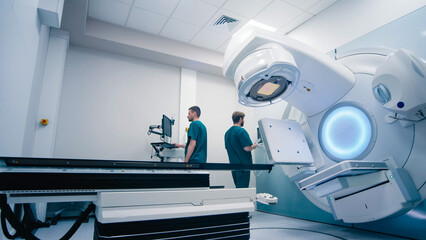 Medical specialists prepare the equipment for radiation therapy in a modern clinic before the...