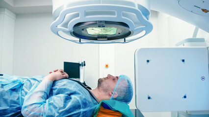 Cancer treatment in a modern medical private clinic or hospital using a linear accelerator. A young...