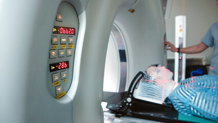 A young woman wearing an immobilization mask undergoes computed tomography before radiation...
