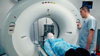 A young woman wearing an immobilization mask for radiotherapy lies in a CT capsule for precise...