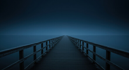 Fototapeta premium Wooden pier jetty extending into calm blue fog over water landscape.