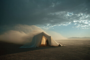 Tent in desert with cloudy sky.