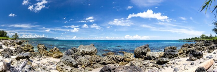 Panoramic View of Rocky Tropical Beach under Bright Blue Sky. Panoramic Beach Landscape with Rocky Shoreline and Cloudy Sky