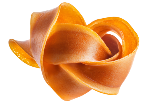 A close up of an orange fruit leather roll shaped like a flower on a black background studio shot